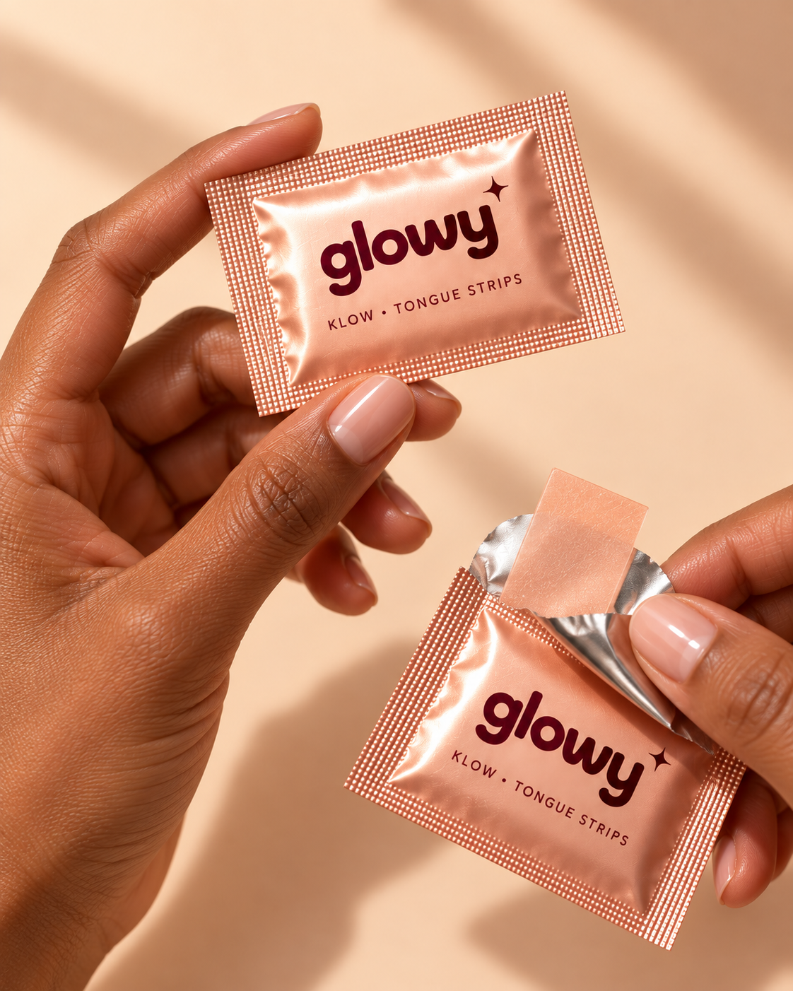 Hands opening an individual Glowy KLOW tongue strip sachet